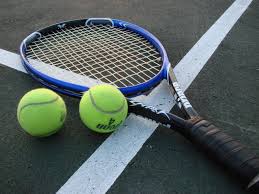 Professional tennis coach demonstrating perfect serve technique on outdoor court